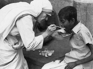 La Madre Teresa mientras alimenta a un niño pobre La Madre Teresa mientras alimenta a un niño pobre